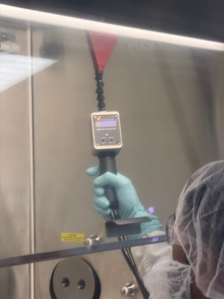 Gloved hand holding measuring device in lab
